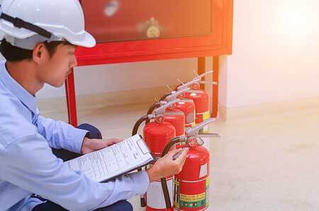 Person Checking Fire Extinguishers